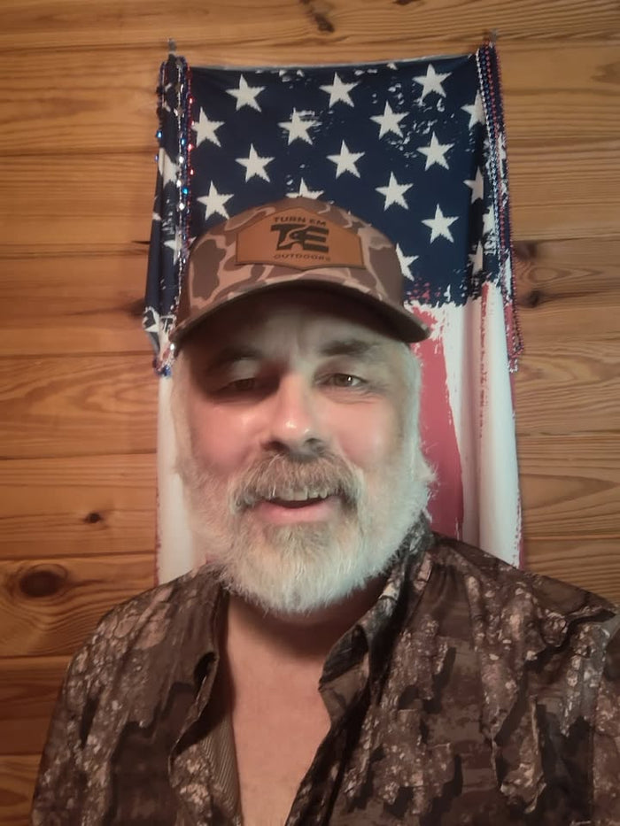 Lifestyle photo of Turn Em Outdoors Timber Camo Richardson leather patch trucker hat while hunting