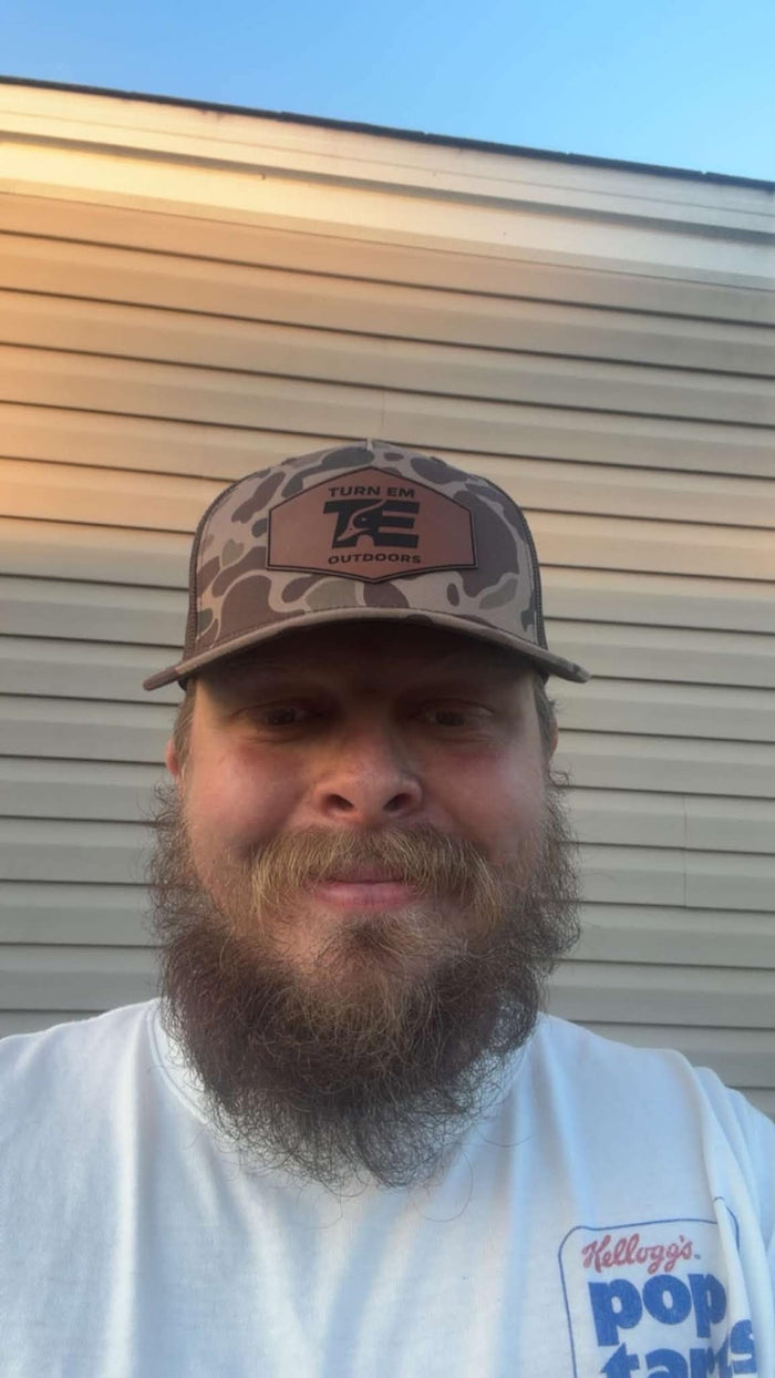 Person wearing Turn Em Outdoors Timber Camo Richardson leather patch trucker hat